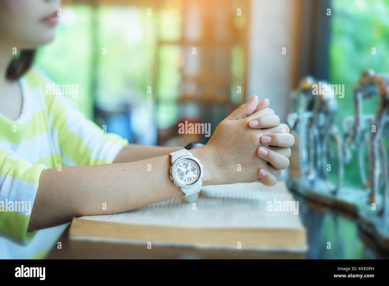 Donna orante della Sacra Bibbia nella mattina. adolescente mano con la Bibbia pregando,mani giunte in preghiera in una Sacra Bibbia nel concetto di chiesa per la fede, Foto Stock