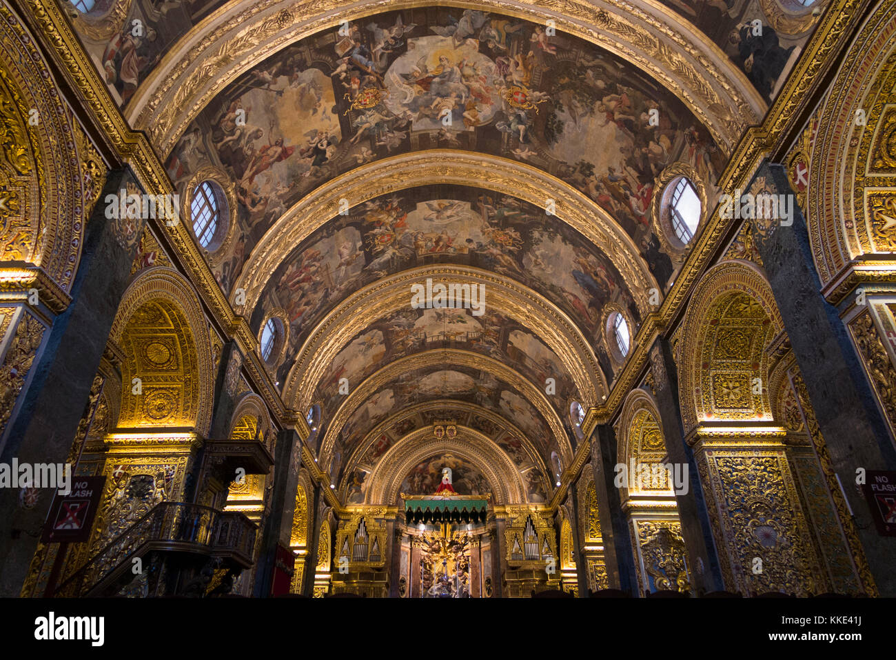 Barocco & altamente soffitto decorato (altare & altare baldacchino in distanza) entro la navata centrale / interni all'interno della Co-Cattedrale di San Giovanni. La Valletta, Malta Foto Stock