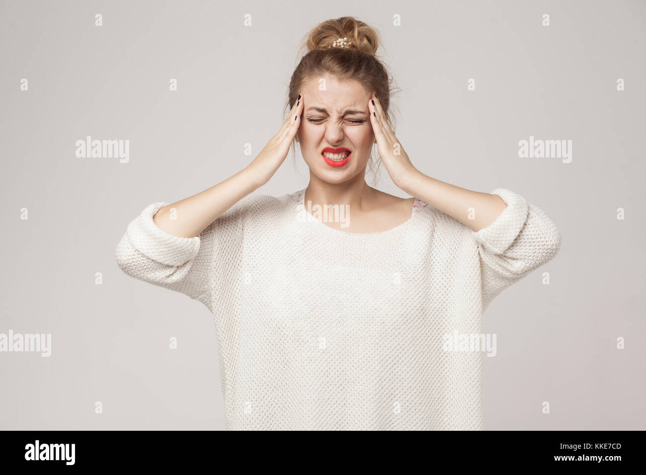Il concetto di dolore, sentimenti cattivi. donna bionda hanno un'emicrania e mal di testa. studio shot Foto Stock