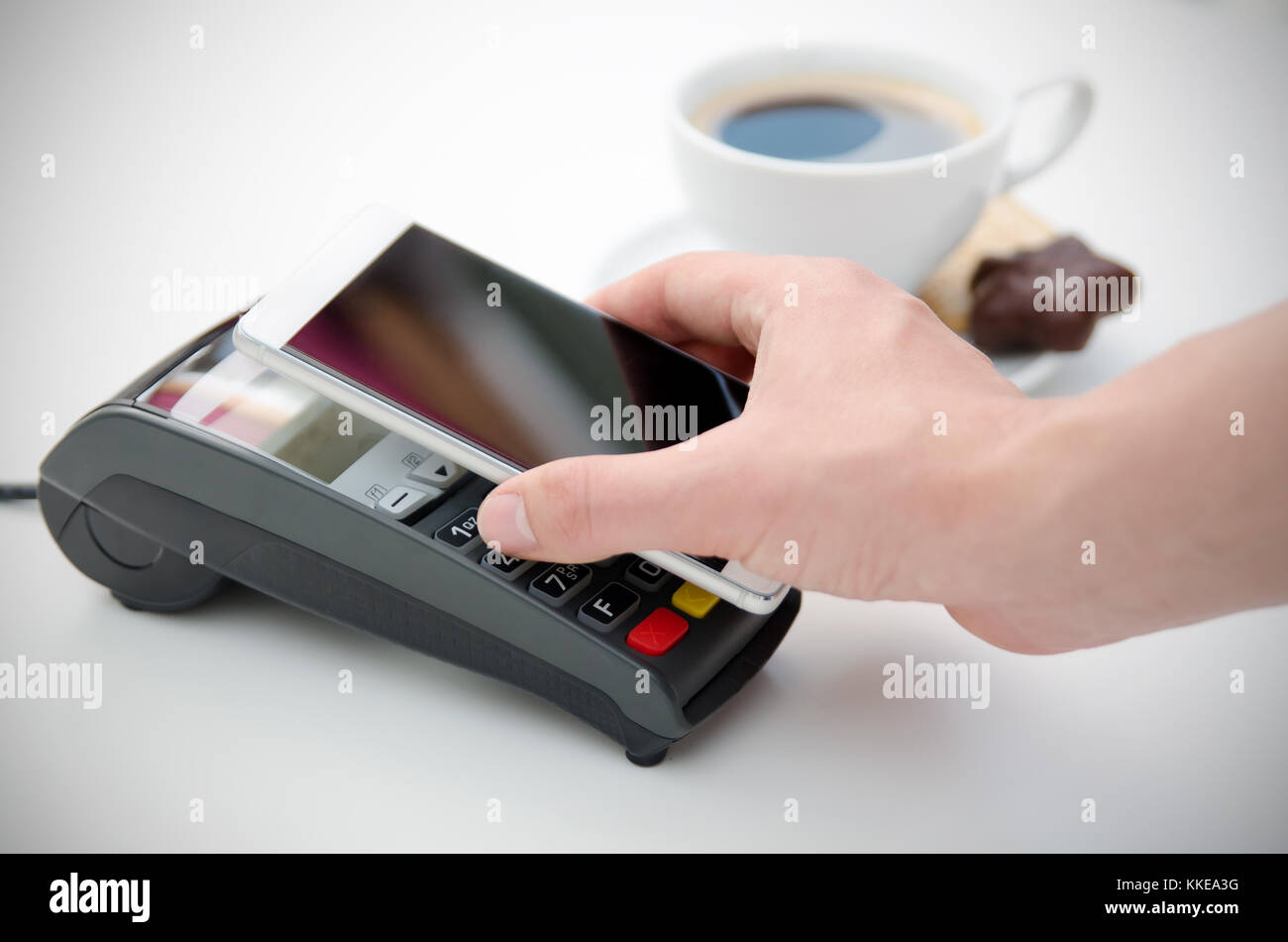 Pagamento mobile in cafe con smart phone nfc near field communication la tecnologia wireless Foto Stock