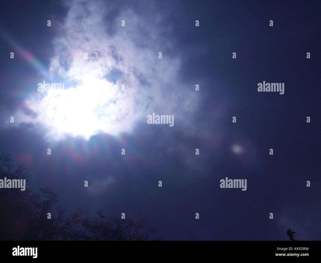 Questa fotografia cattura il momento in cui il sole emerge dopo una forte pioggia a Quezon City, Filippine. La luce si irrompe tra le nuvole, proiettando un caldo bagliore sulla città, evidenziando il contrasto tra le strade piovose e il cielo luminoso. Foto Stock