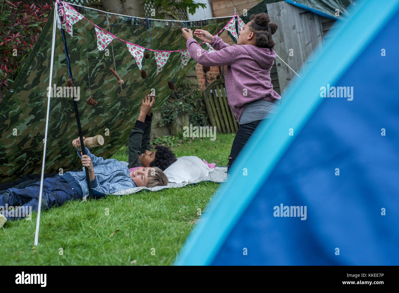 Big wild sleepout caso pix . immagini di giovani ragazzi/ i bambini e i genitori nel loro giardino sul retro da circa la metà del pomeriggio fino a tarda sera-tempo, godendo di attività, come ad esempio fare un den, guardando i bug, mettendo fuori il cibo per cani per il riccio, di tostatura marshmallows intorno a un falò, falena trappola, cercando per animali notturni. Foto Stock