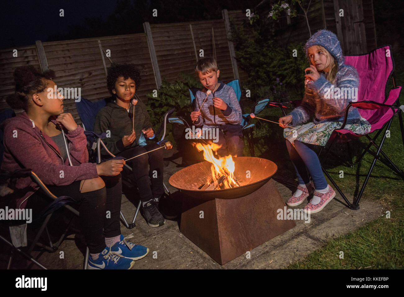 Big wild sleepout caso pix . immagini di giovani ragazzi/ i bambini e i genitori nel loro giardino sul retro da circa la metà del pomeriggio fino a tarda sera-tempo, godendo di attività, come ad esempio fare un den, guardando i bug, mettendo fuori il cibo per cani per il riccio, di tostatura marshmallows intorno a un falò, falena trappola, cercando per animali notturni. Foto Stock