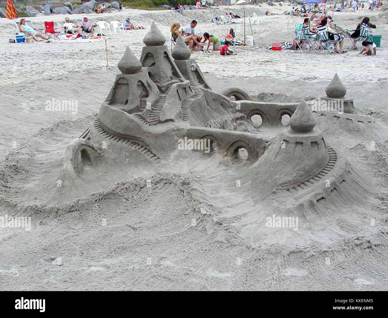 Un castello di sabbia meticolosamente realizzato su una spiaggia, che mostra disegni e torri intricati, esemplificando l'arte della scultura della sabbia. Foto Stock