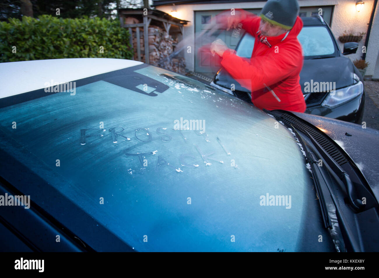 Flintshire, Nord, Regno Unito meteo. artic chill e condizioni di congelamento rimangono ancora su molte parti del regno unito oggi il primo giorno di inverno secondo il calendario meteorologico. Un uomo ghiaccio di compensazione di un parabrezza congelata con le parole frosty jack scritto nel ghiaccio prima del suo treno di Flintshire, Galles credito: Foto Stock