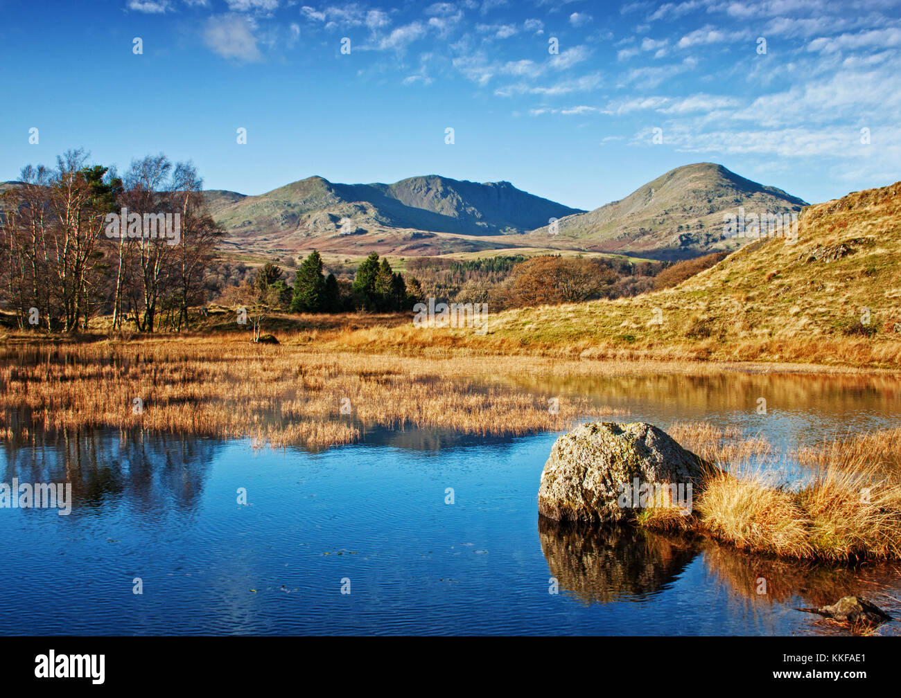 La quiete di Kelly hall tarn, con il vecchio di coniston gracing sullo sfondo Foto Stock