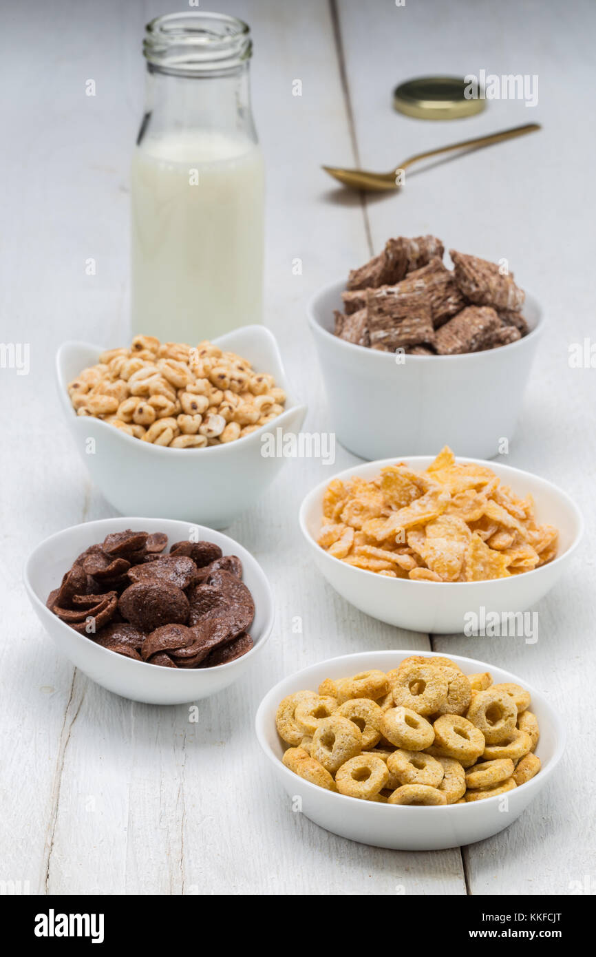 Varie conrflake cereali in ciotole e latte. Foto Stock