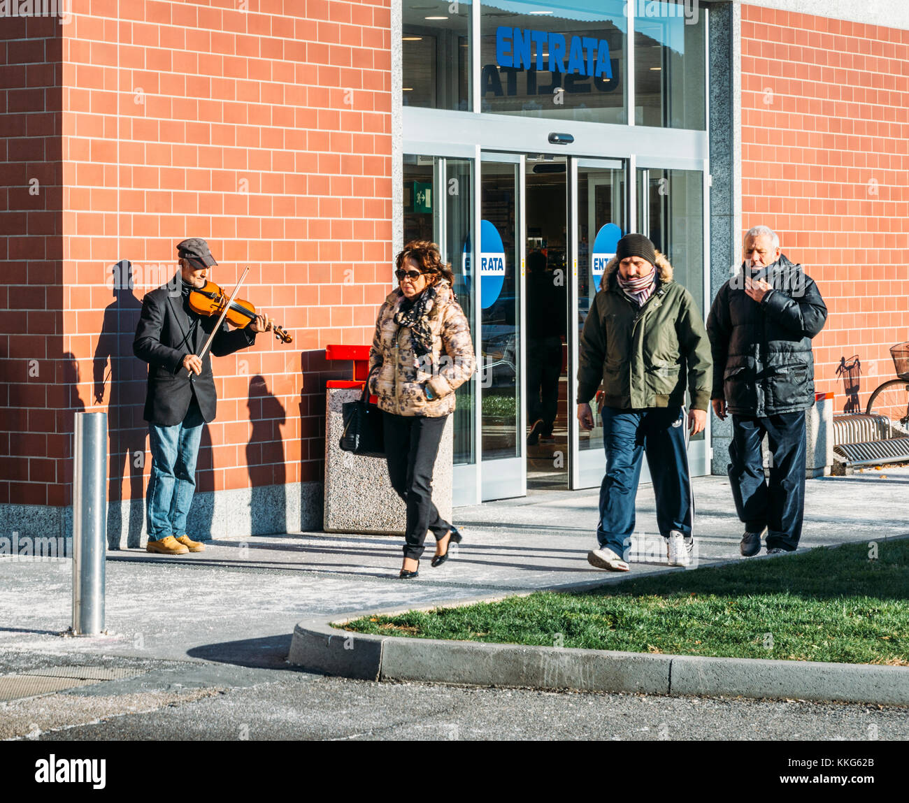 Il vecchio uomo street performer riproduzione di un violino al di fuori di un supermercato a milano, lombardia, italia Foto Stock