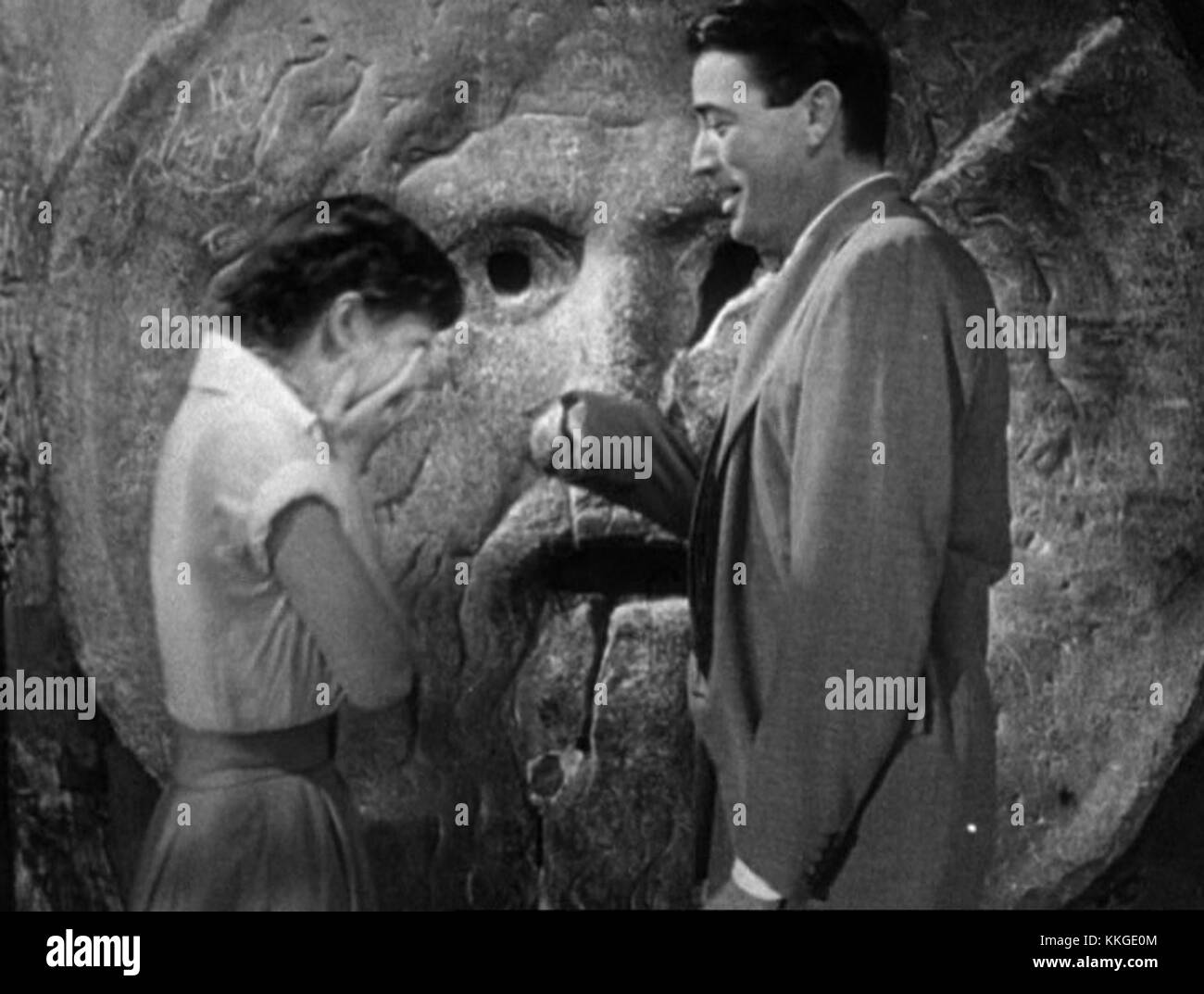 Scena del trailer "Vacanze Romane" con Audrey Hepburn e Gregory Peck alla bocca della verità a Roma. Il momento iconico mostra la chimica degli attori e la narrazione romantica del film. Foto Stock
