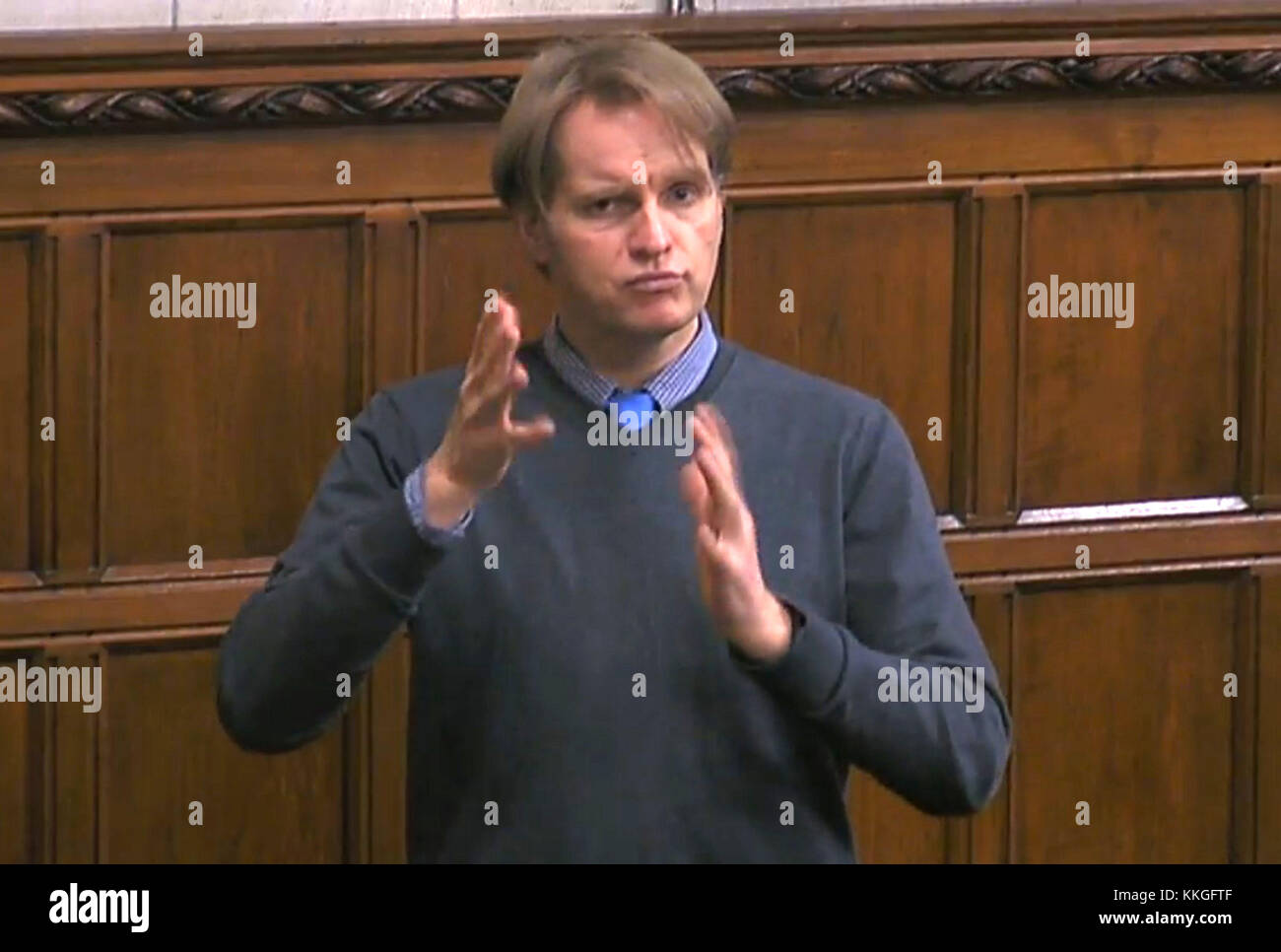 Un britannico interprete del linguaggio dei segni da azione sulla perdita di udito segni durante un dibattito di Commons. Foto Stock