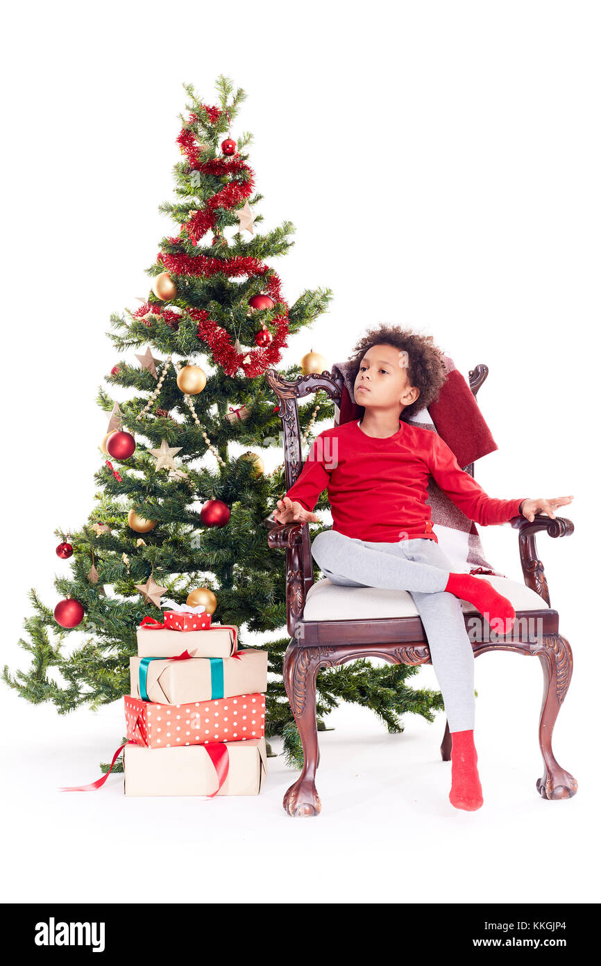 Razza mista boy vicino albero di natale Foto Stock