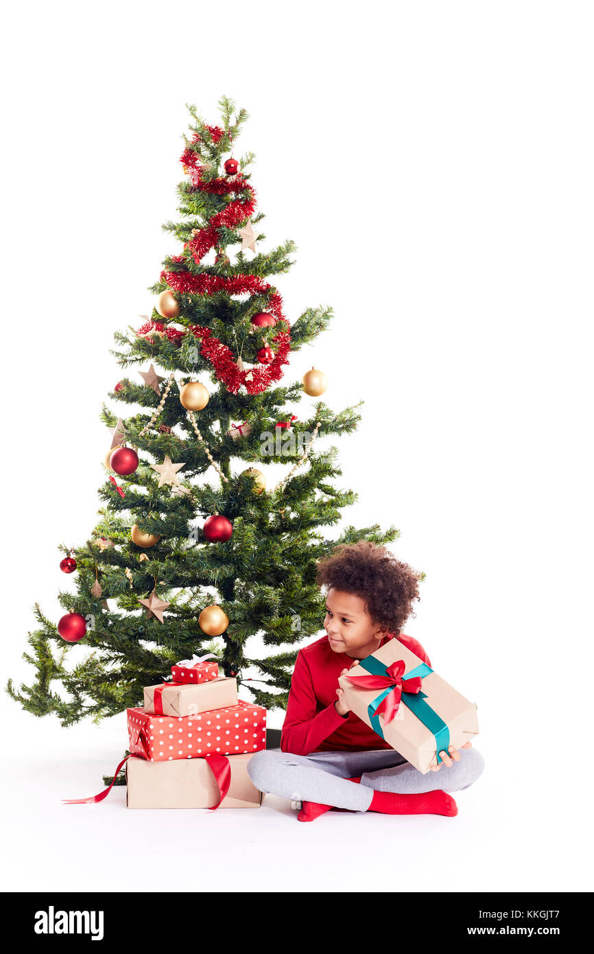 Razza mista boy vicino albero di natale Foto Stock