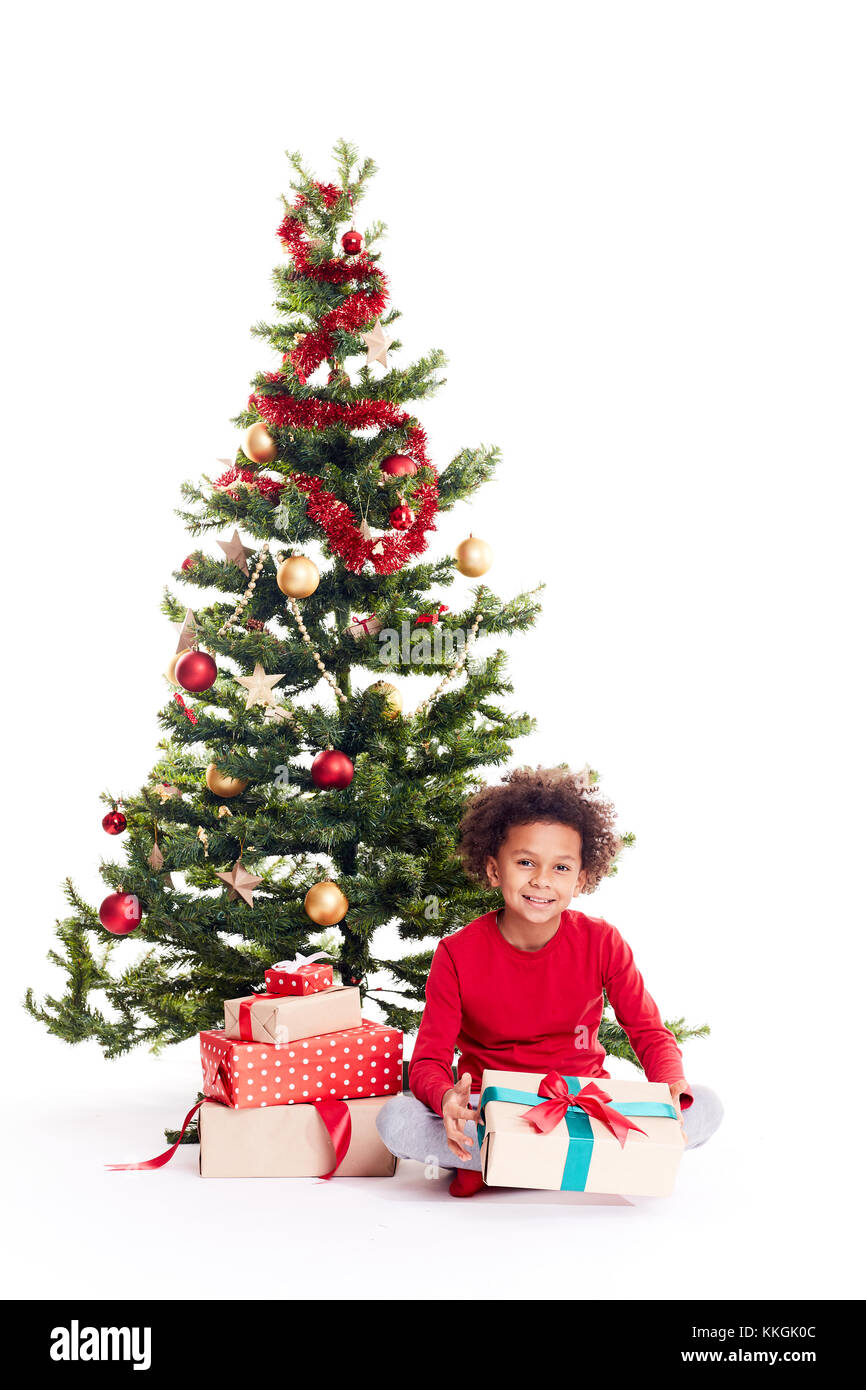 Razza mista boy vicino albero di natale Foto Stock