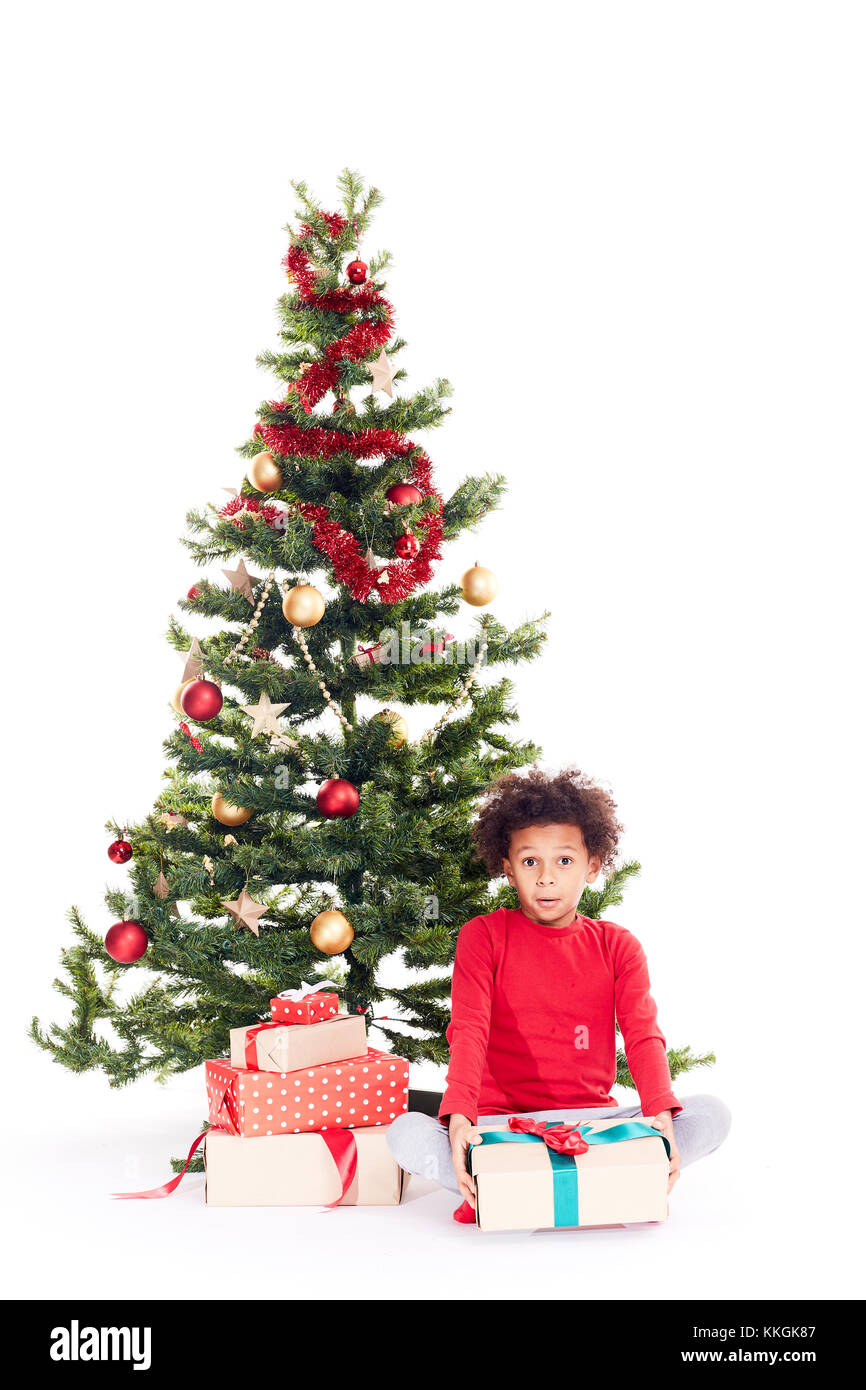 Razza mista boy vicino albero di natale Foto Stock