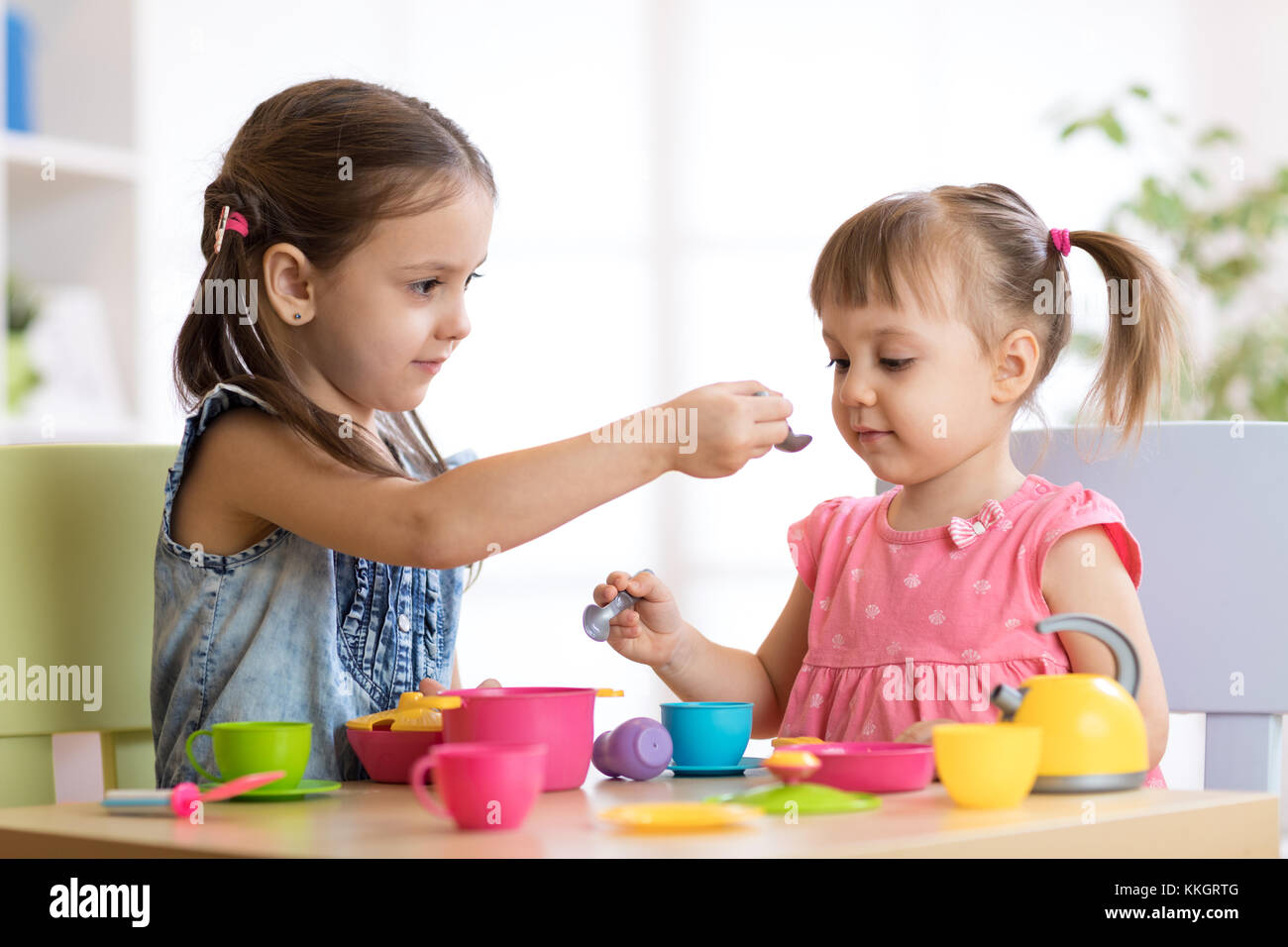 Bambini che giocano con stoviglie di plastica Foto Stock