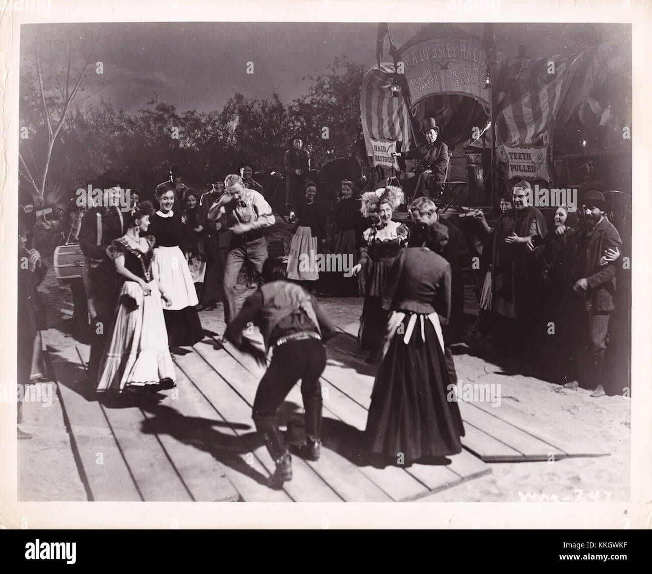 Questo ancora tratto dal film "Wagon Master" cattura un momento di danza quadrata, una tradizionale danza popolare americana, evidenziando il significato culturale della danza nel contesto del Vecchio West. Foto Stock