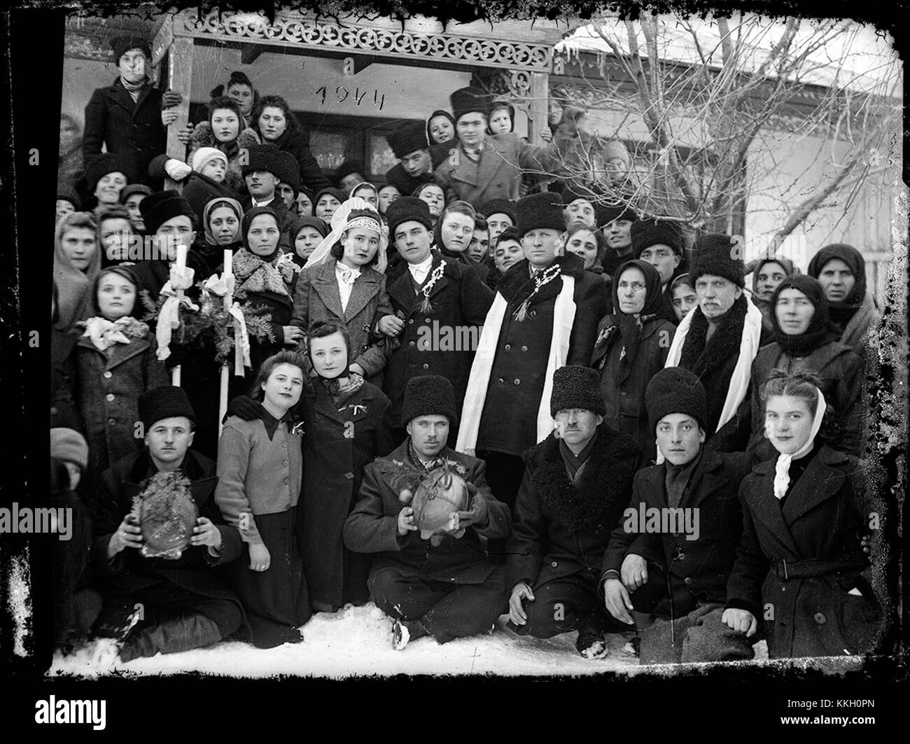 Questa fotografia, scattata nell'inverno del 1944, mostra una cerimonia di nozze tradizionale in Romania. L'immagine riflette le pratiche culturali e i costumi del tempo, evidenziando il ruolo della famiglia e della comunità nella celebrazione del matrimonio. Foto Stock