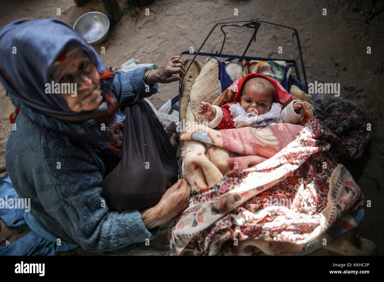 Una donna di 70 anni veglia su suo nipote all'interno della loro casa primitiva nell'area priva di infrastrutture di al-Mughraga a Gaza, Striscia di Gaza, i territori palestinesi, 29 novembre 2017. Un numero crescente di famiglie a Gaza sta affrontando la povertà in mezzo a elevati tassi di disoccupazione e alla mancanza di opportunità di lavoro a causa del blocco della Striscia di Gaza, in vigore dal 2007. Foto: Wissam Nassar/dpa Foto Stock Una donna di 70 anni veglia su suo nipote all'interno della loro casa primitiva nell'area priva di infrastrutture di al-Mughraga a Gaza, Striscia di Gaza, i territori palestinesi, 29 novembre 2017. Un numero crescente di famiglie a Gaza sta affrontando la povertà in mezzo a elevati tassi di disoccupazione e alla mancanza di opportunità di lavoro a causa del blocco della Striscia di Gaza, in vigore dal 2007. Foto: Wissam Nassar/dpa Foto Stock