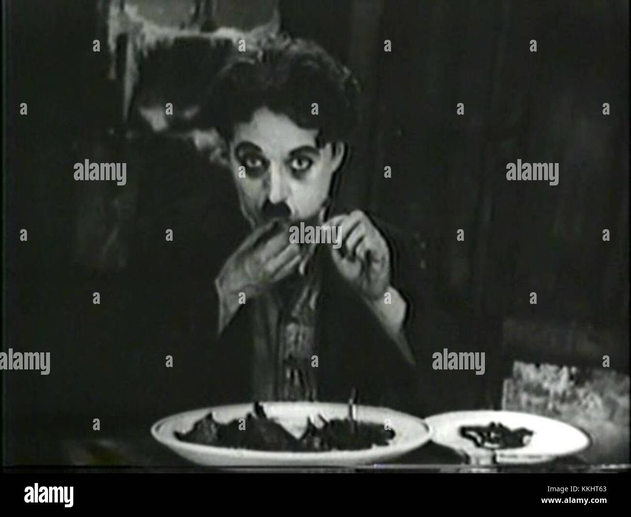 Una scena dell'iconico film di Charlie Chaplin del 1925, *la corsa all'oro*, in cui il personaggio di Chaplin mangia umoristicamente le sue scarpe a causa della fame estrema. Questa scena rimane uno dei momenti più memorabili della storia del cinema. Foto Stock