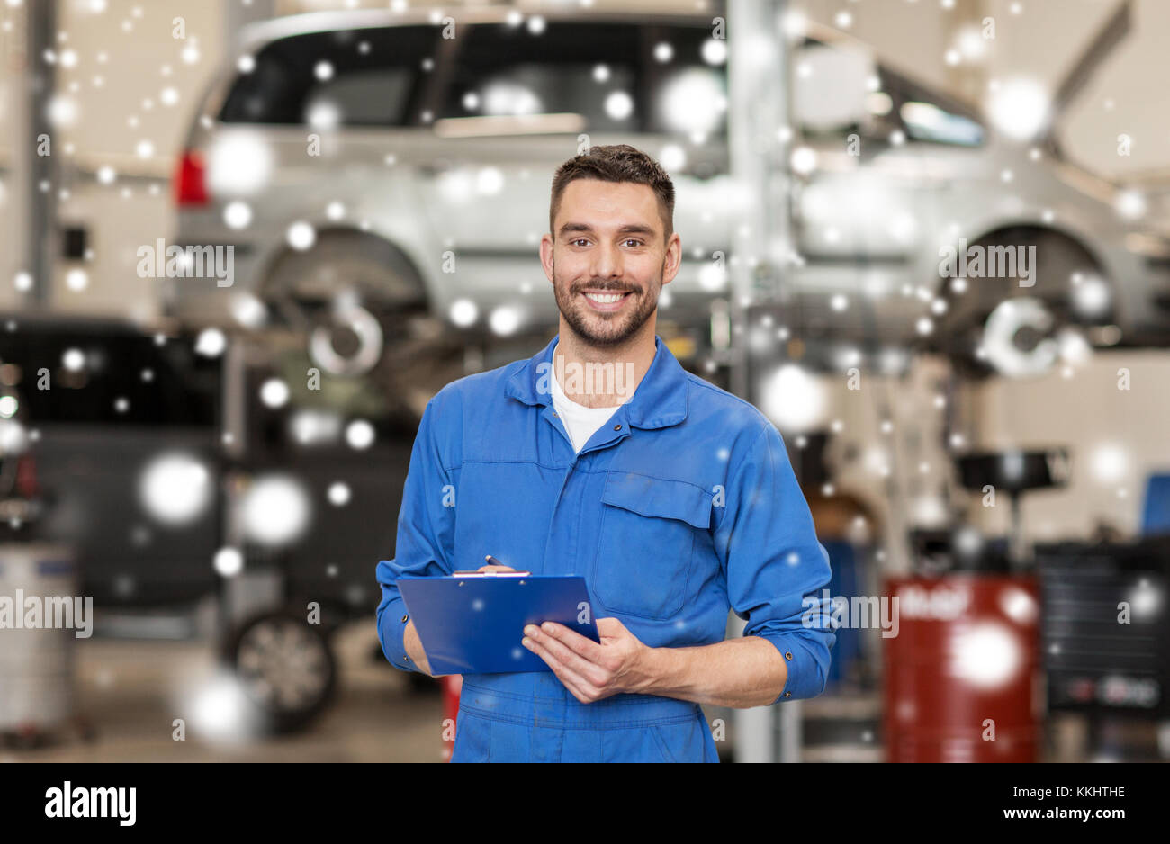 Felice l'uomo meccanico con appunti in officina per auto Foto Stock