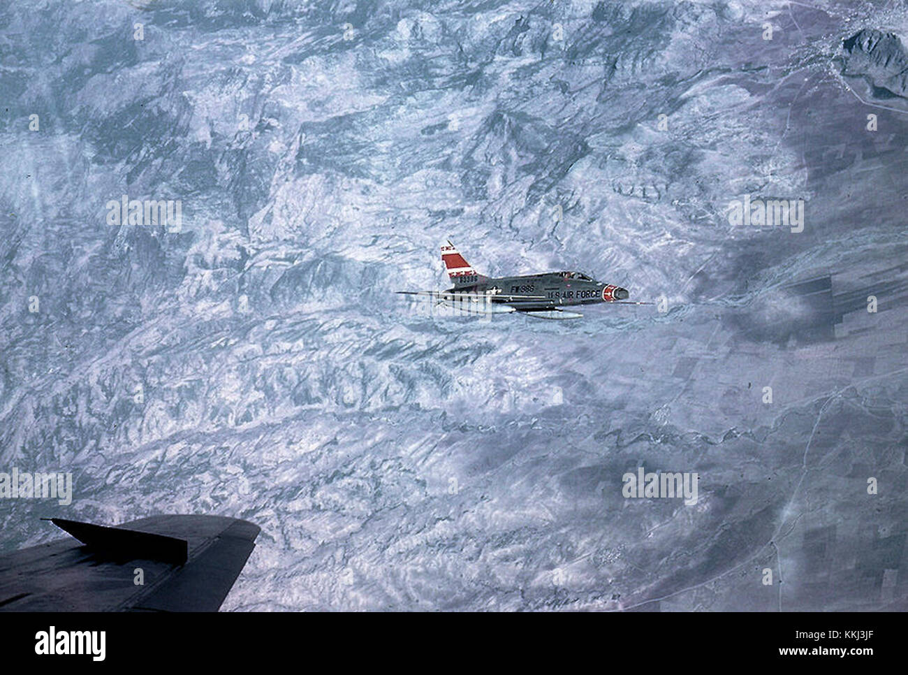 L'F-100 Super Sabre, coda numero 56-3388, del 353rd Tactical Fighter Squadron, è visto volare sopra le Alpi. L'aereo rappresenta un periodo significativo nella storia dell'aviazione della Guerra fredda, evidenziando la tecnologia dell'aviazione militare. Foto Stock