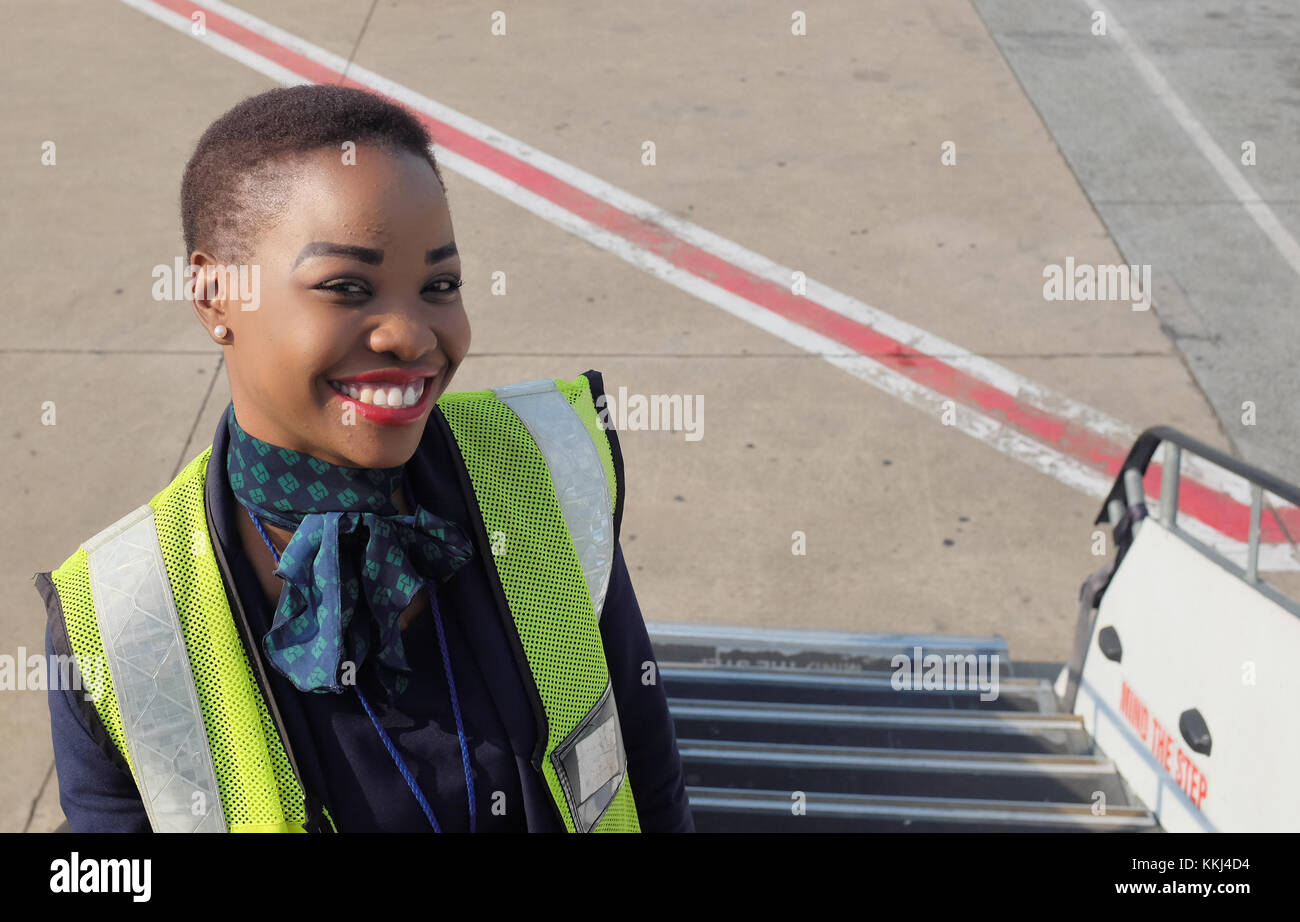 Un dipendente della compagnia aerea si erge sulla scalinata che conduce ad un volo British Airways da Johannesburg a Cape Town dopo i passeggeri sono imbarcati. Foto Stock