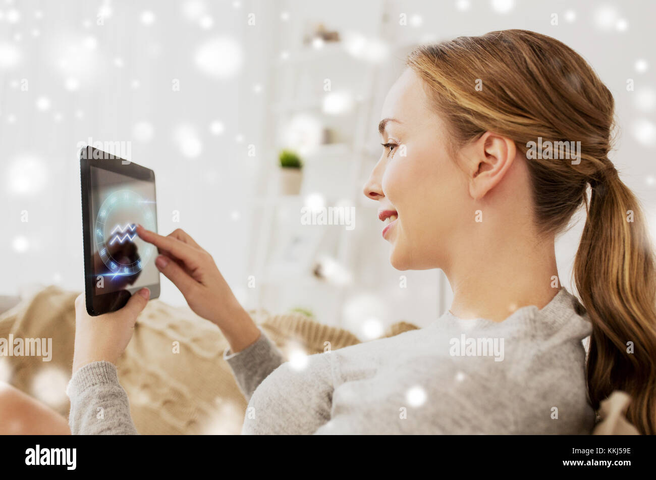 Donna sorridente con segni di zodiaco su tablet pc Foto Stock