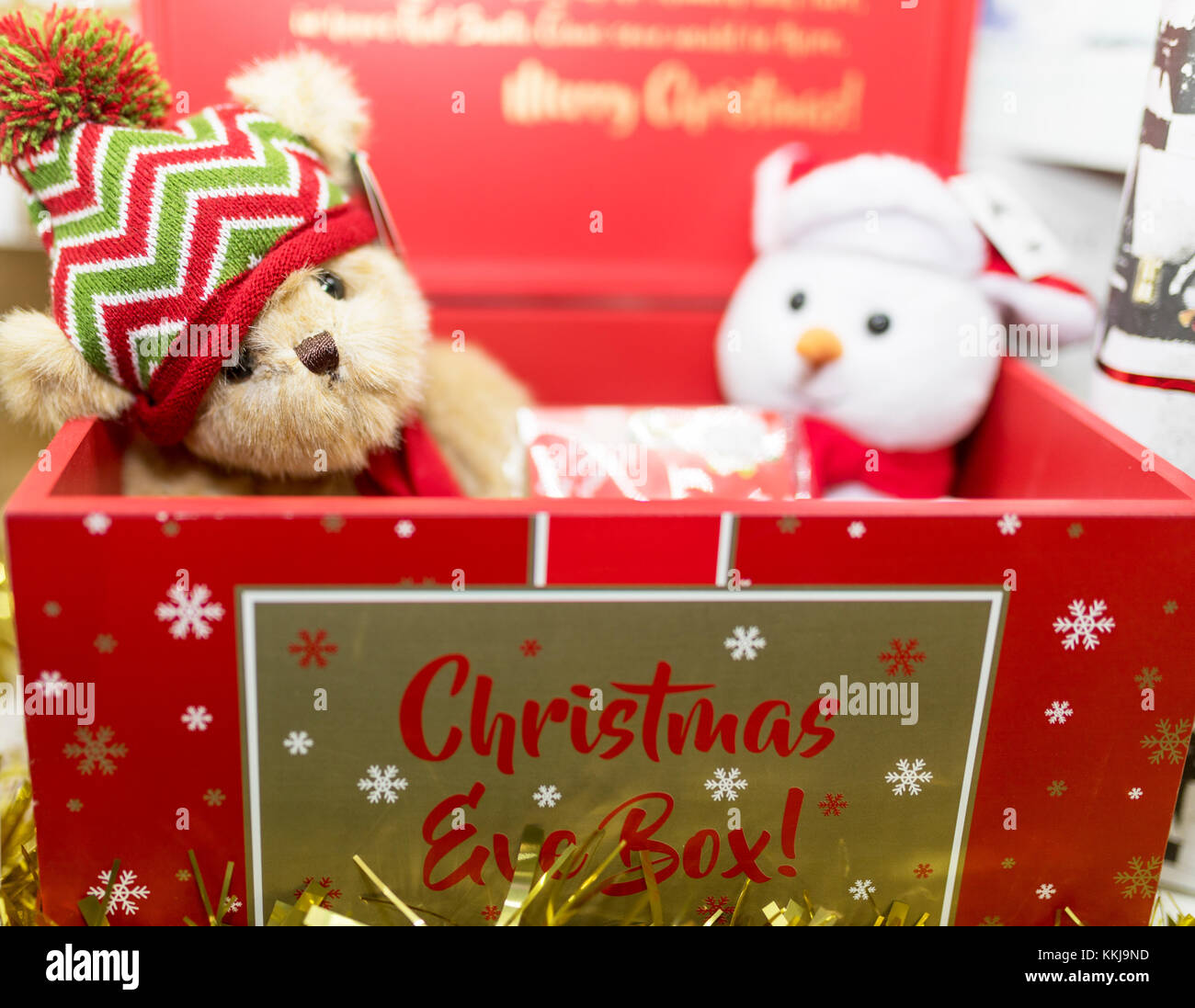 Vintage marrone festosa orsacchiotto di peluche che indossa un cappellino in un rosso Natale confezione regalo con un morbido peluche pupazzo di neve nel Regno Unito Foto Stock