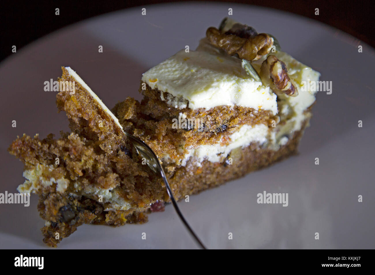 Torta di carote servita su una piastra bianca. Le funzioni di torta di fondente e noci. Foto Stock
