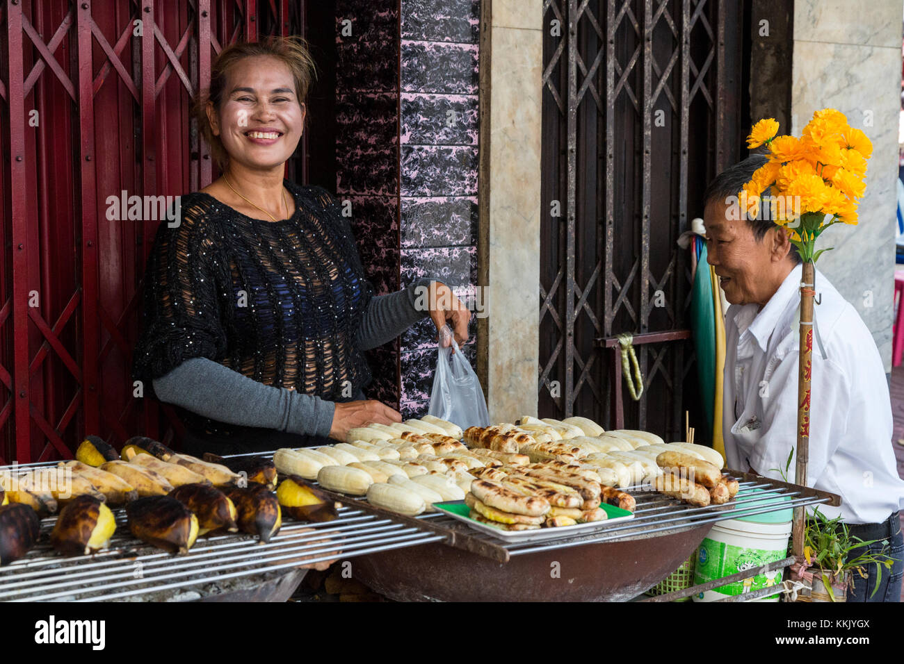 Bangkok, Tailandia. Cucina di strada venditore a vendere banane arrosto. Foto Stock