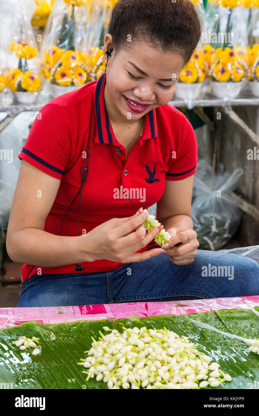 Bangkok, Tailandia. Pak Khlong Market (Mercato dei Fiori). Giovane donna Stringing fiori di gelsomino. Foto Stock