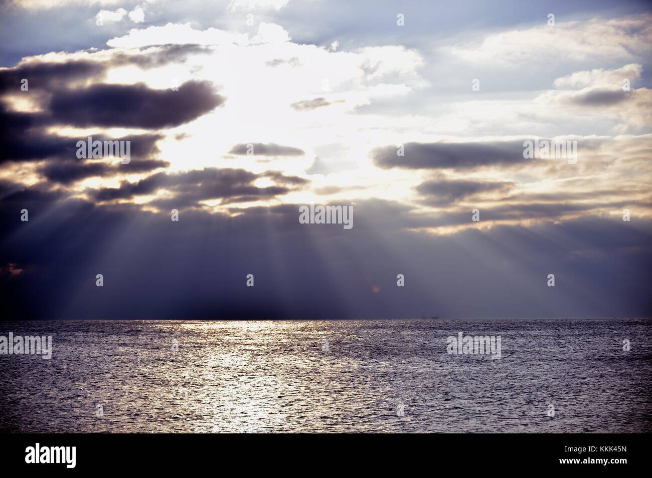 Flussi di luce dal cielo come il sole si rompe al di sopra di nuvole sopra il lago Michigan off shore di Montrose Harbor a Chicago, Illinois, Stati Uniti d'America. Foto Stock