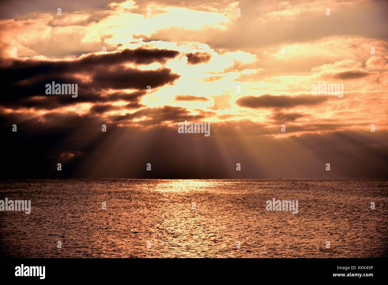 Flussi di luce dal cielo come il sole si rompe al di sopra di nuvole sopra il lago Michigan off shore di Montrose Harbor a Chicago, Illinois, Stati Uniti d'America. Foto Stock