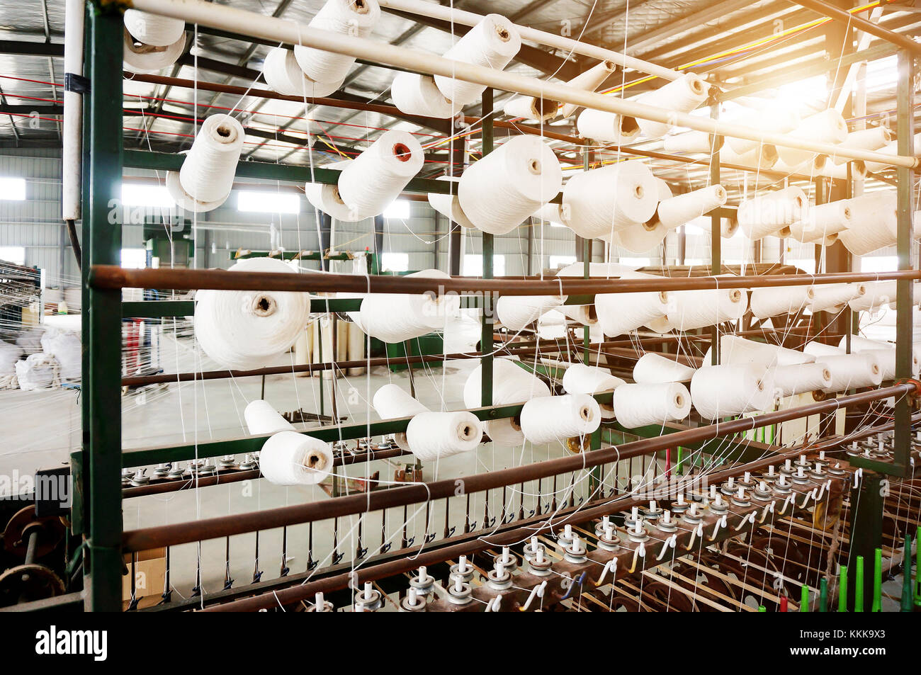Industria tessile - bobine di filato su una macchina di filatura in una fabbrica tessile Foto Stock