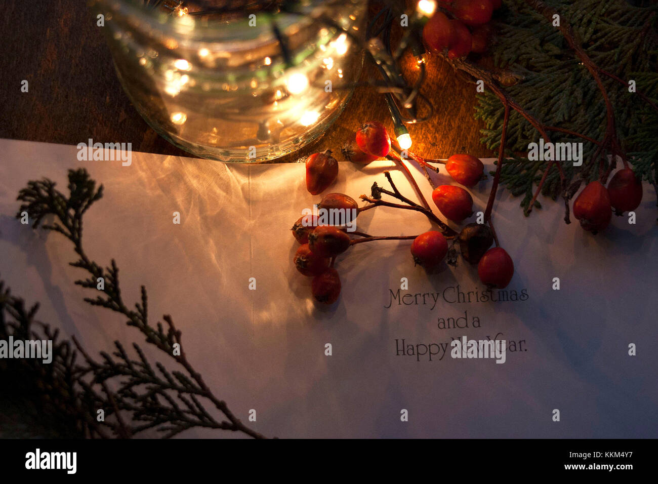Un vaso contenente lampadine sul tavolo e un biglietto di auguri di Natale Foto Stock