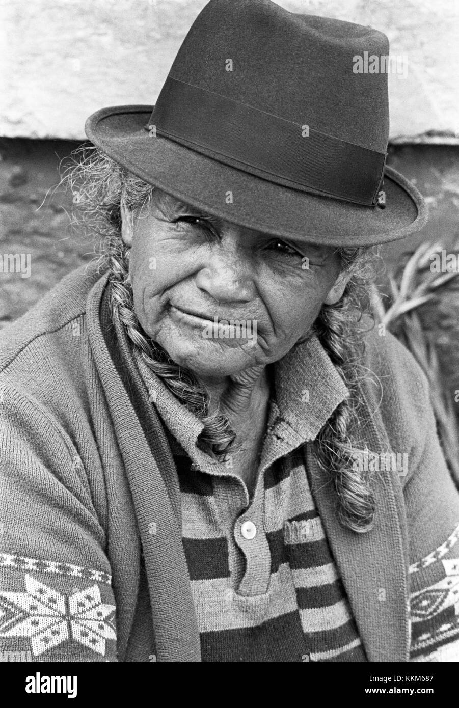 Un anziano fornitore del mercato in un vegetale stand nel mercato ecuadoriano città di Otovalo, Ecuador, alta delle Ande montagne. Foto Stock