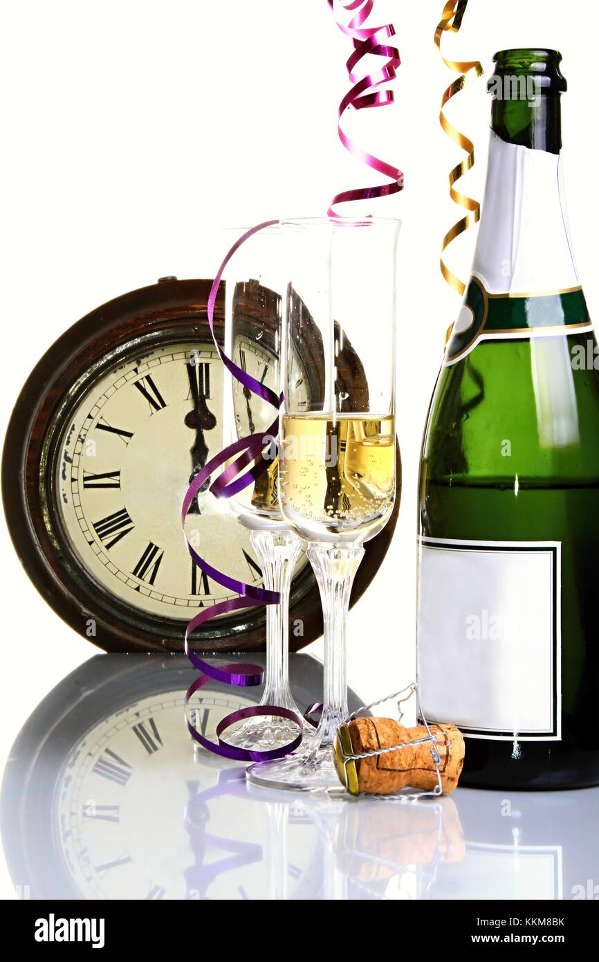 Anno nuovo orologio in background con un mezzo riempito un bicchiere di  champagne con streamers anche una bottiglia e tappo di sughero sul tavolo  Foto stock - Alamy