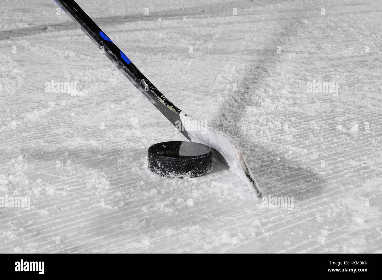 Hockey su ghiaccio la memory stick e puck sulla superficie del ghiaccio, close-up Foto Stock