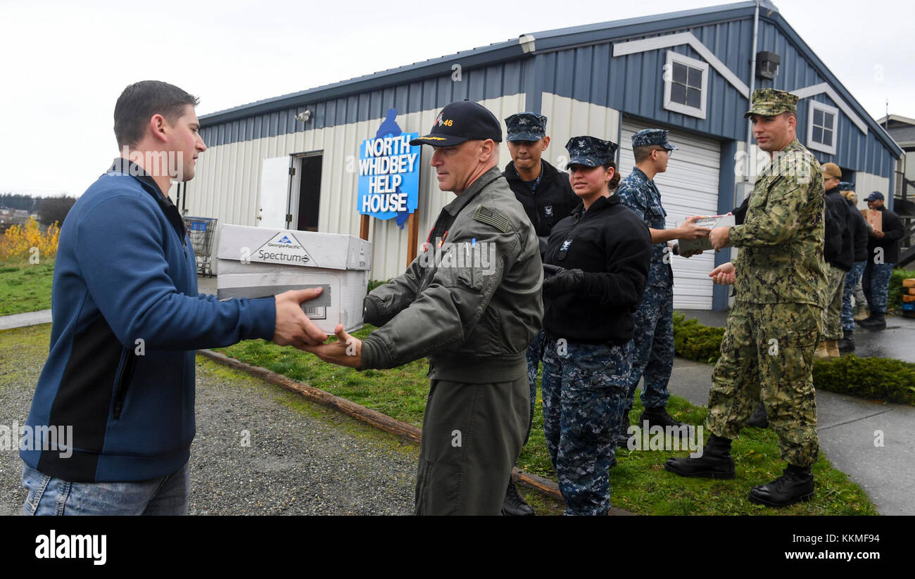 OAK HARBOR, Washington (21 novembre 2017) i marinai di stanza alla base aerea navale di Whidbey Island scaricano il cibo dagli autobus scolastici locali di Whidbey Island alla North Whidbey Help House sull'isola di Whidbey come parte dell'evento di beneficenza un-Stuff the Bus. L'evento ha offerto ai marinai l'opportunità di sostenere la comunità locale con autobus 'senza farcitura' che le scuole locali hanno riempito di cibo per la North Whidbey Help House da consegnare alle famiglie in necessità di ringraziamento. (STATI UNITI Navy foto da Mass Communication Specialist 2 ° Classe Scott Wood / rilasciato) Foto Stock