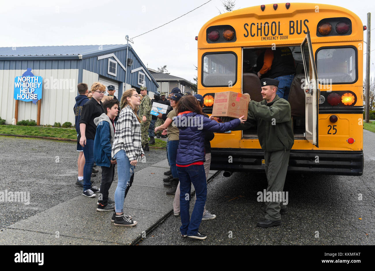 OAK HARBOR, Washington (21 novembre 2017) Naval Air Station i marinai e i bambini di Whidbey Island delle scuole locali aiutano a scaricare il cibo dagli autobus scolastici di Whidbey Island presso la North Whidbey Help House sull'isola di Whidbey, come parte dell'evento di beneficenza un-Stuff the Bus. L'evento ha offerto ai marinai l'opportunità di sostenere la comunità locale con autobus 'senza farcitura' che le scuole locali hanno riempito di cibo per la North Whidbey Help House da consegnare alle famiglie in necessità di ringraziamento. (STATI UNITI Navy foto da Mass Communication Specialist 2 ° Classe Scott Wood / rilasciato) Foto Stock