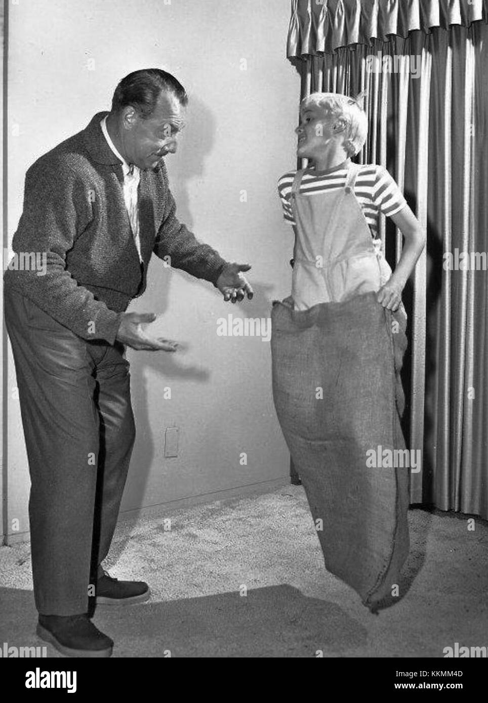 Questa immagine del 1962 mostra Gale Gordon e Jay North che partecipano a una gara di sack legata al popolare show televisivo "Dennis the Menace". L'immagine cattura un momento divertente della serie. Foto Stock