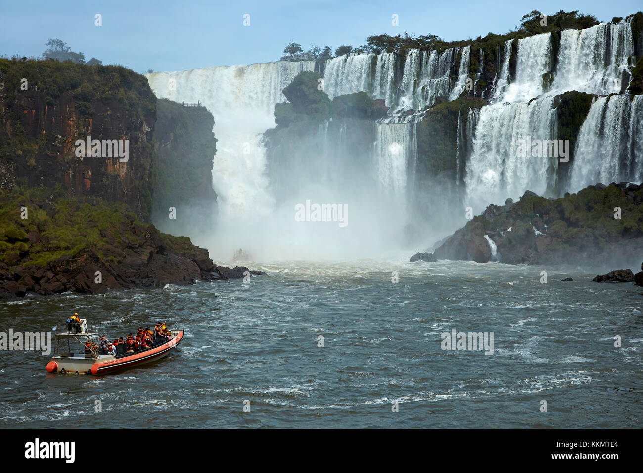 Turisti in barca che passa sotto le cascate Iguazu, Argentina, Sud America Foto Stock