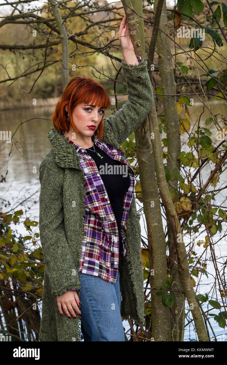 Redhead ragazza camminare sulla strada forestale in autunno Foto Stock