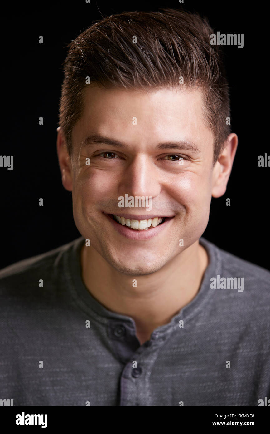 Sorridente giovane uomo bianco cercando di fotocamera, ritratto verticale Foto Stock