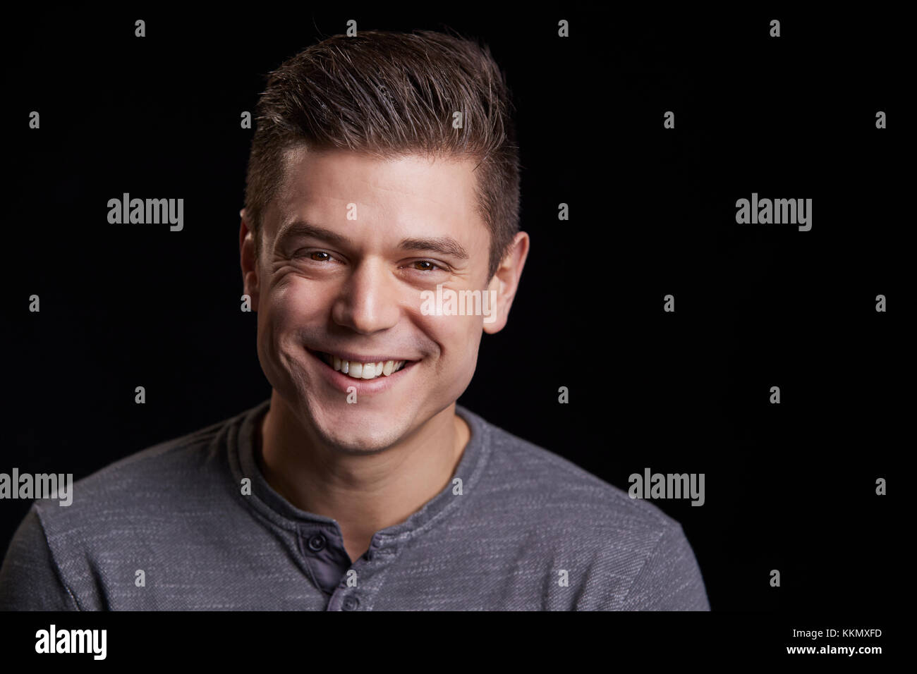 Ritratto di un sorriso bianco giovane uomo che guarda alla fotocamera Foto Stock