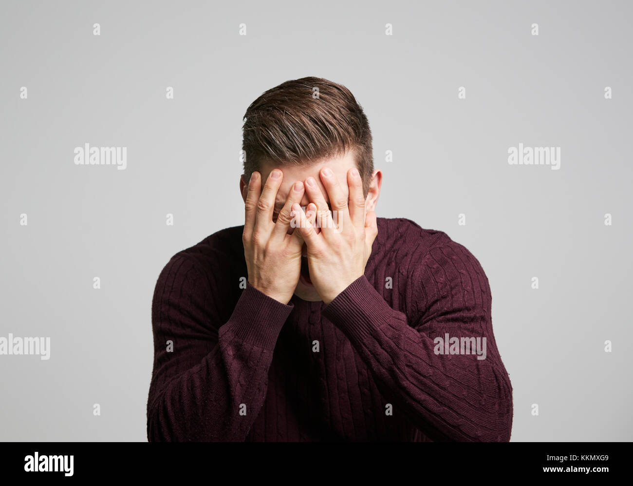 Ritratto di un giovane uomo bianco con le mani che coprono il suo volto Foto Stock
