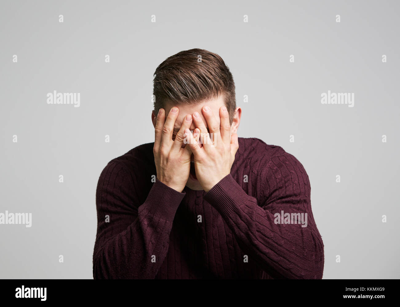 Ritratto di un giovane uomo bianco con le mani che coprono il suo volto Foto Stock Ritratto di un giovane uomo bianco con le mani che coprono il suo volto Foto Stock