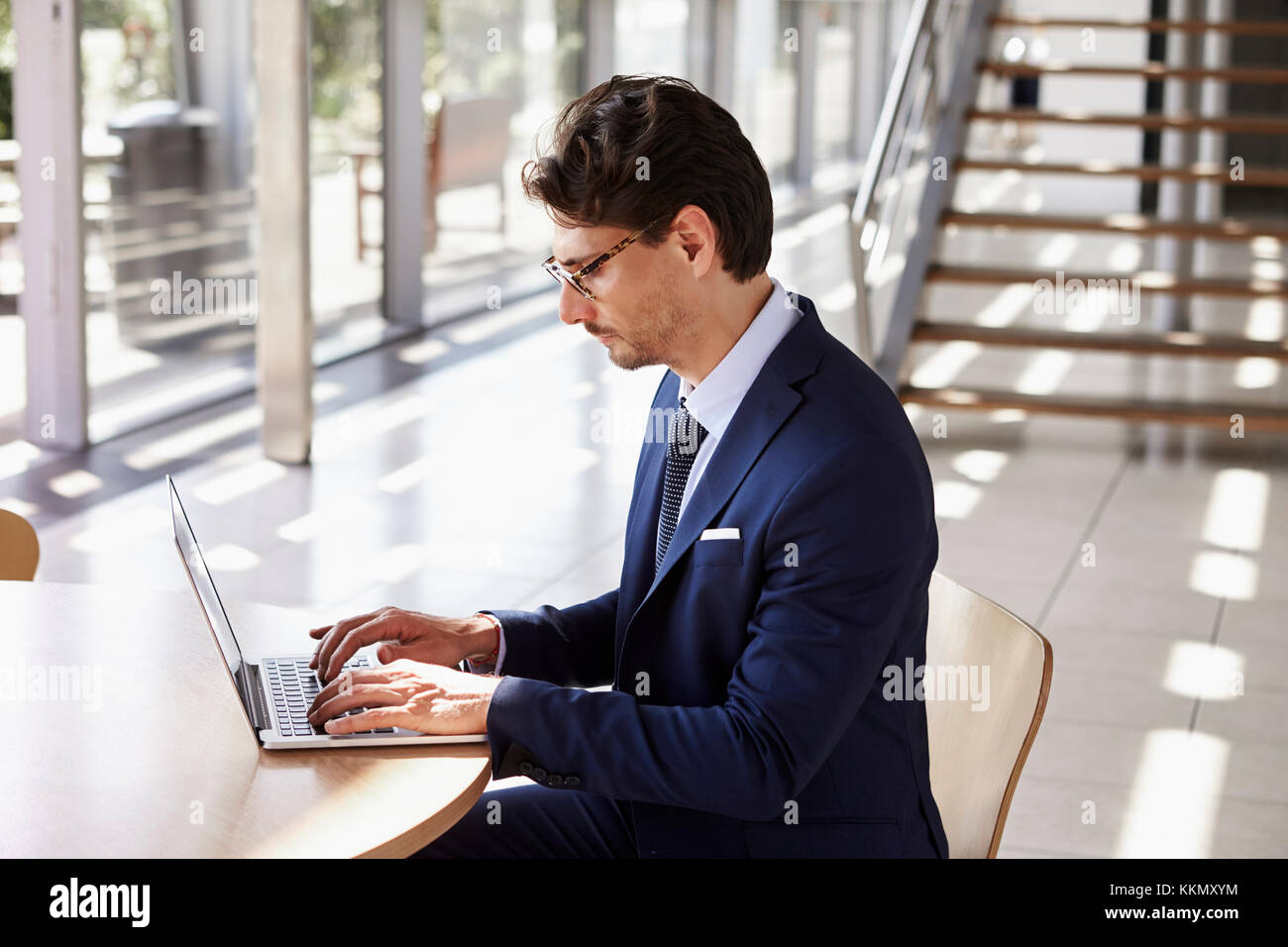 Giovane uomo professionale utilizzando laptop, vista in elevazione Foto Stock