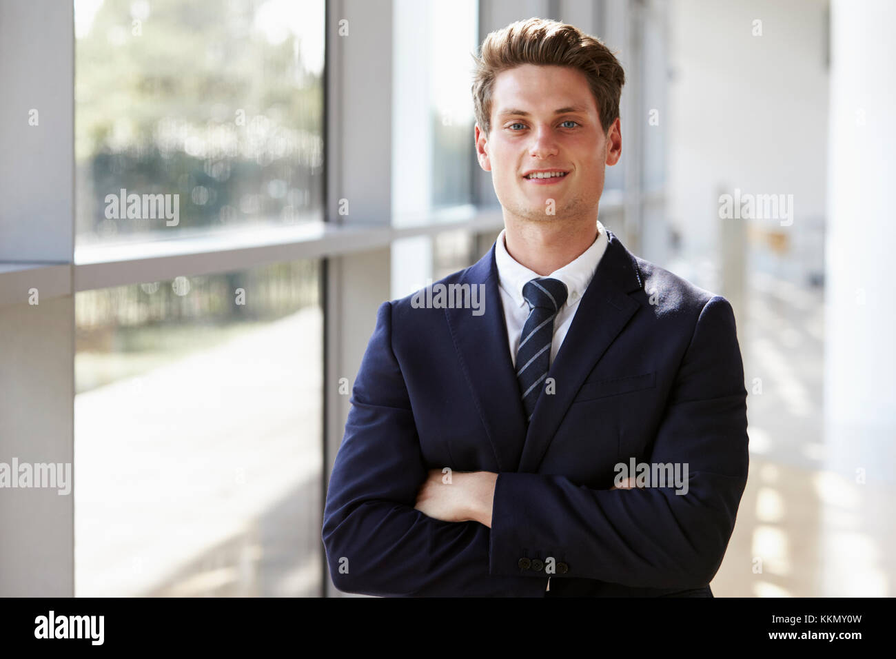 Ritratto di un giovane sorridente uomo professionale, con le braccia incrociate Foto Stock