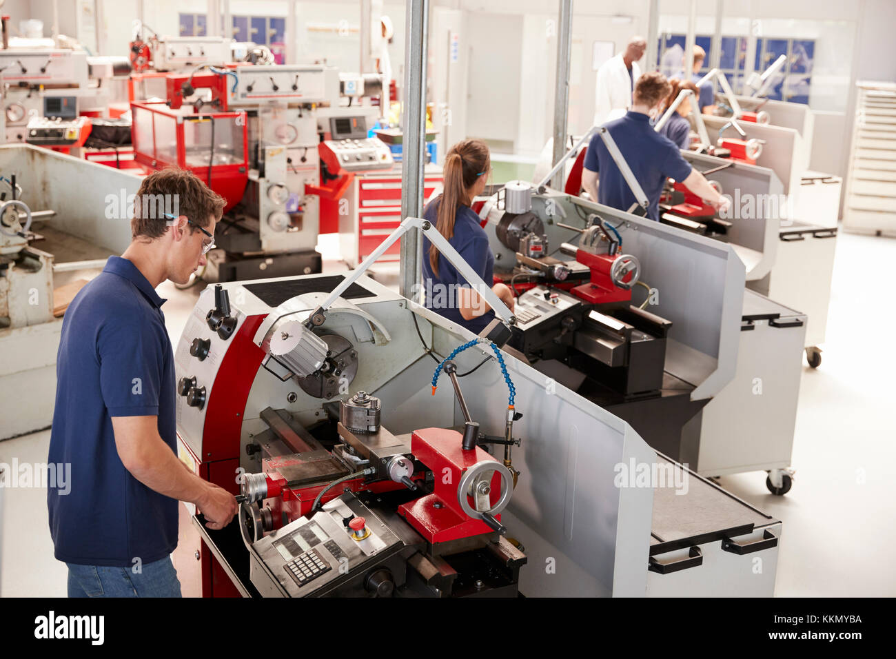 Gli Ingegneri tirocinanti le apparecchiature operative in una piccola fabbrica Foto Stock